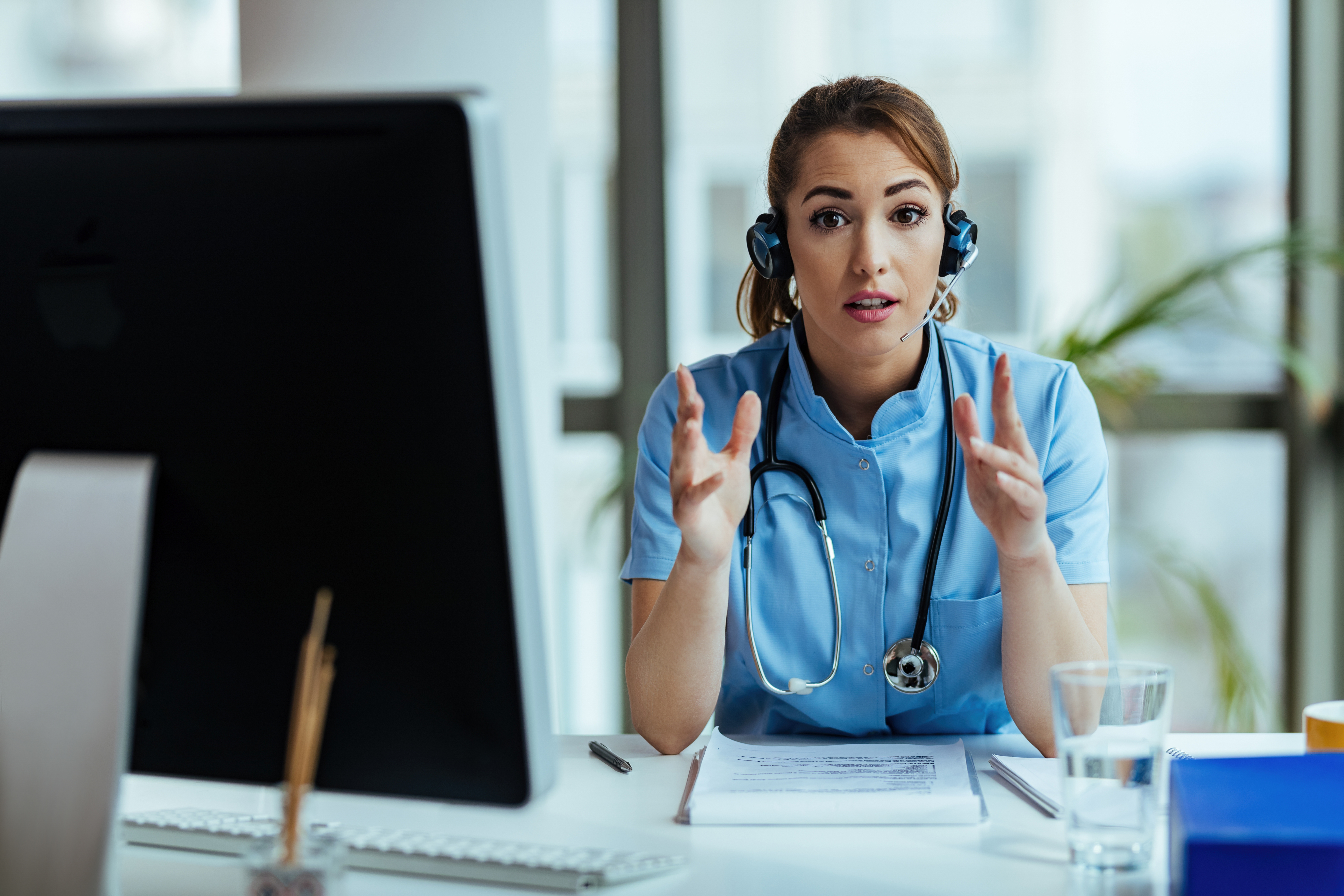 Young nurse with headset providing support while working at medi